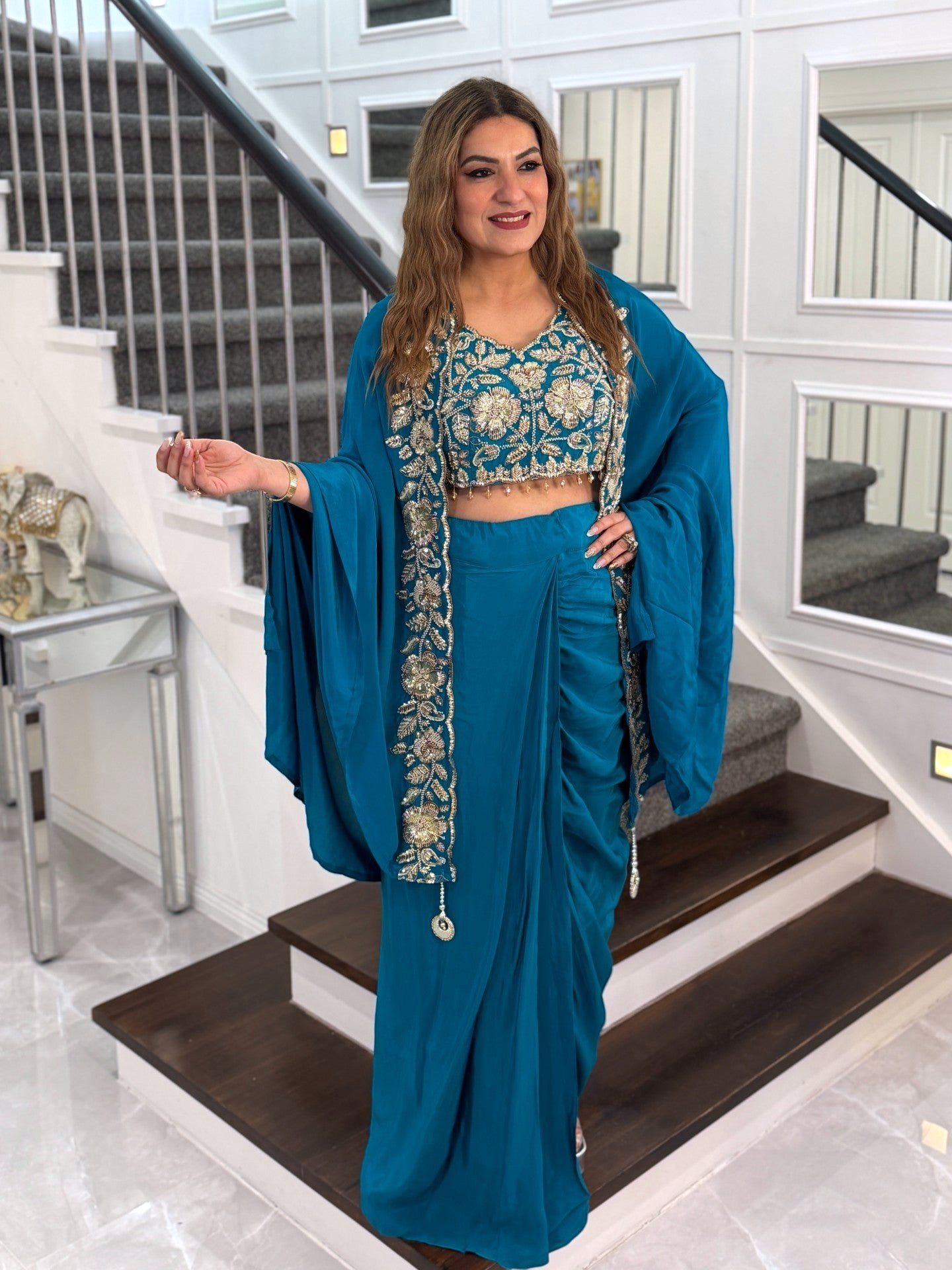 PanacheByDivya teal indo-western outfit with embroidered crop top, matching skirt, and flowing cape for parties.
