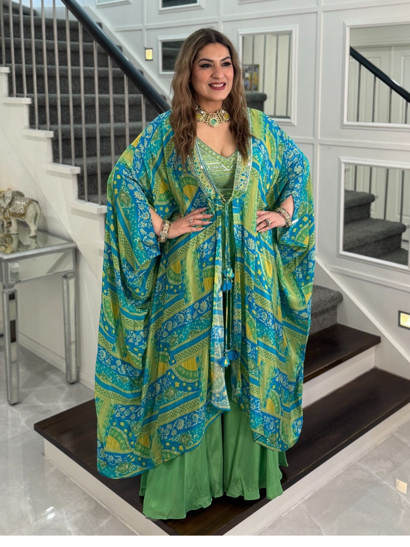 Woman wearing a PanacheByDivya premium Indo-western outfit with a blue and green patterned kaftan and matching pants.
